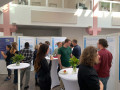 A group of people are gathered in a bright indoor atrium for a professional event or conference.